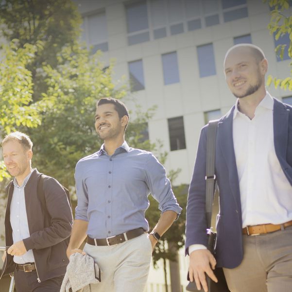 Ein internationales Team ist gemeinsam auf dem parkähnlichen Gelände des Business Campus Unterschleißheim unterwegs